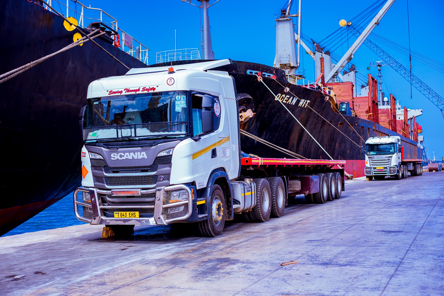 SAS Logistics truck positioned beside a cargo vessel at the port